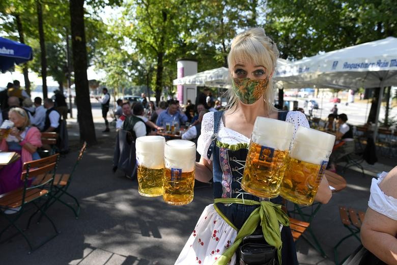 A server carries mugs during a barrel tapping at a beer garden near Theresienwiese where Oktoberfest would have started today, in Munich, Germany. REUTERS/Andreas Gebert  